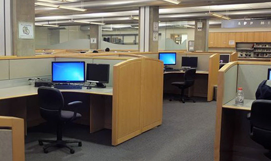 Computer lab with wooden cublicles and desktop computers